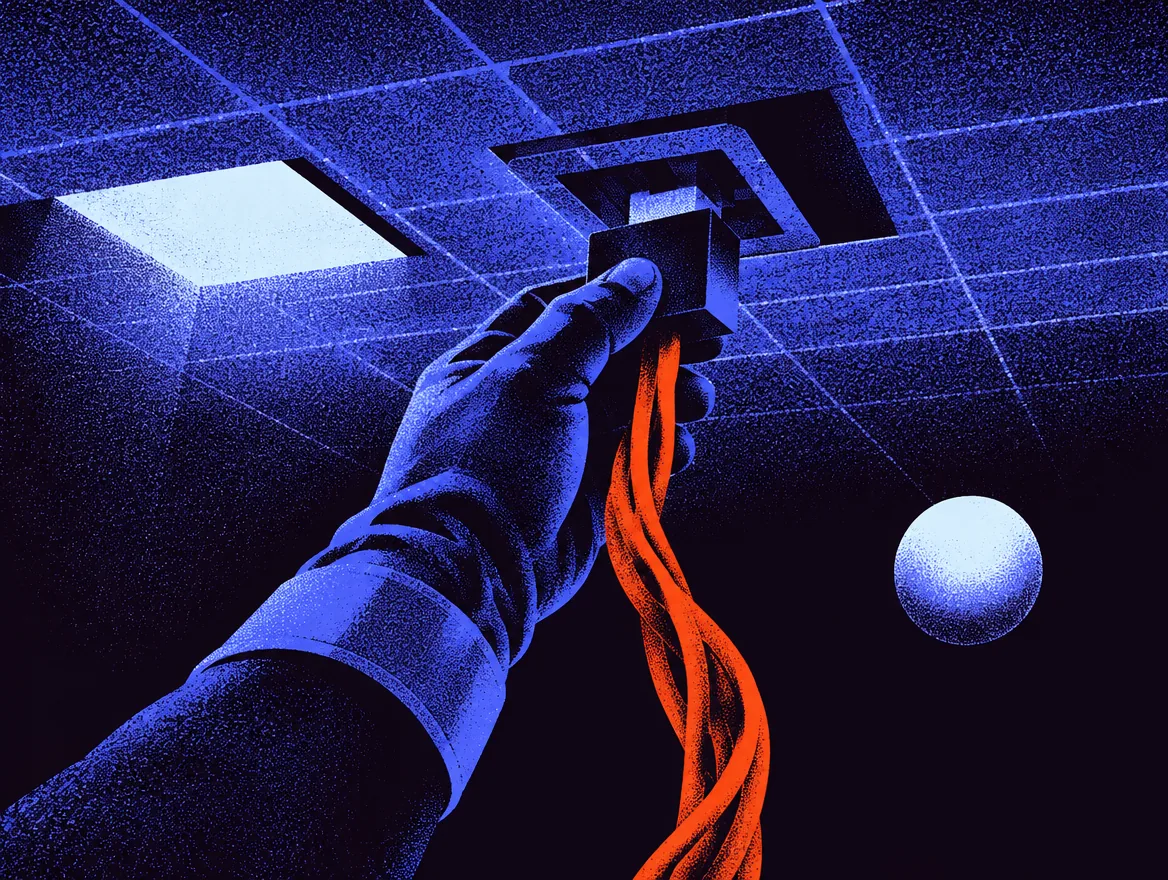 A gloved hand plugs an orange cable into a socket under the floor